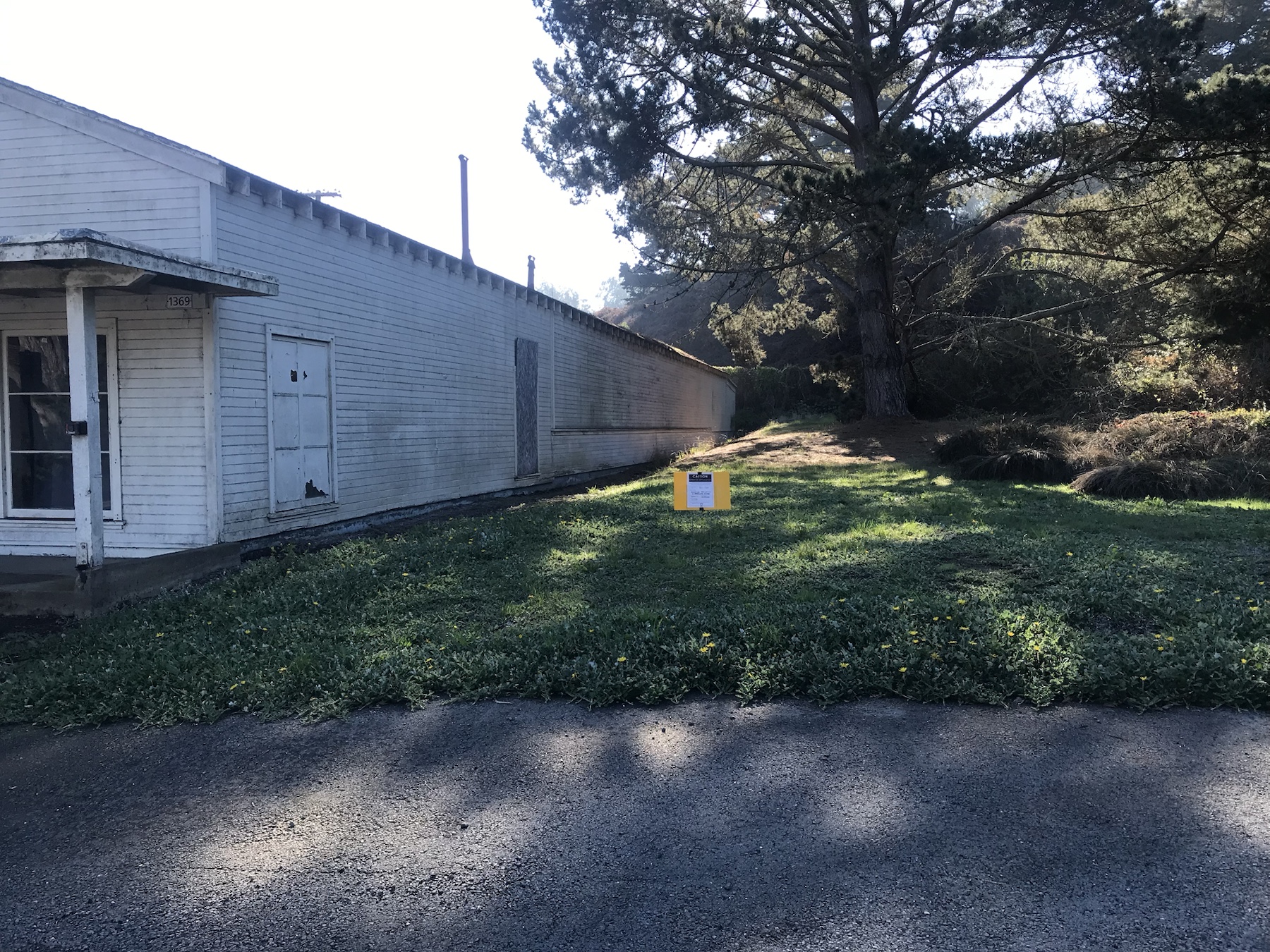 Herbicide application sign posted in lawn area beside Presidio Building 1369