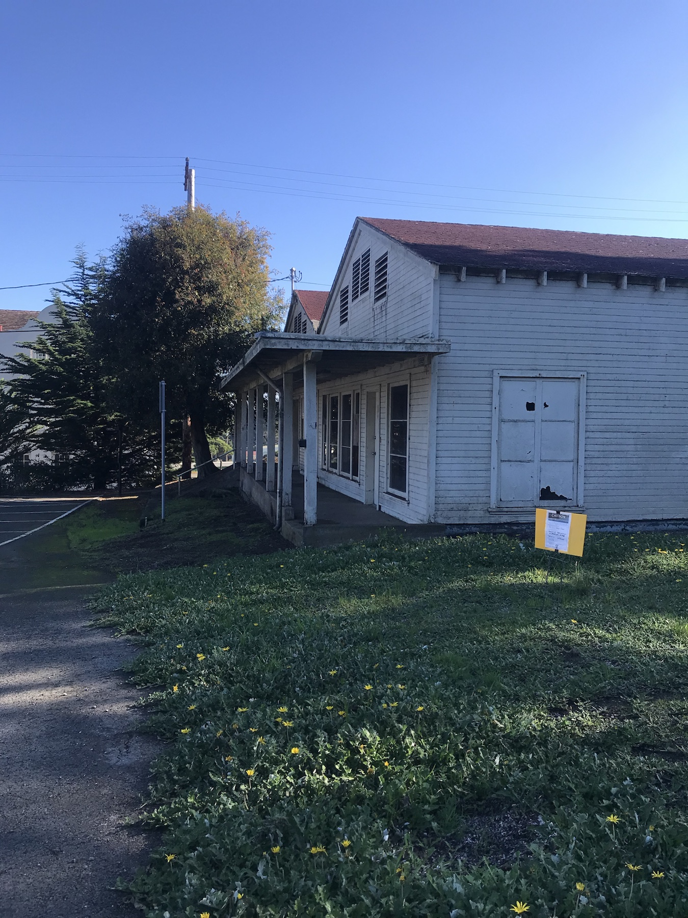 Wider context image of a herbicide application sign near Building 1369 in the Presidio
