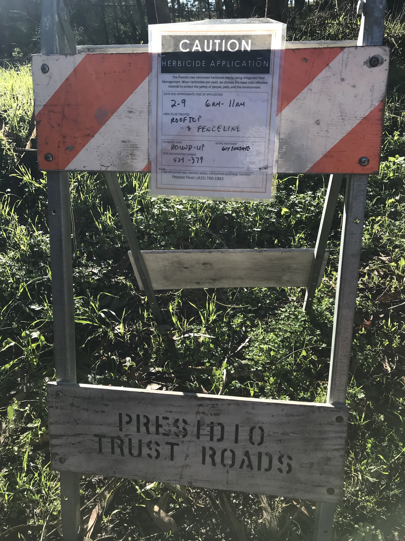 Caution herbicide application sign listing Roundup and glyphosate for rooftop and fenceline treatment