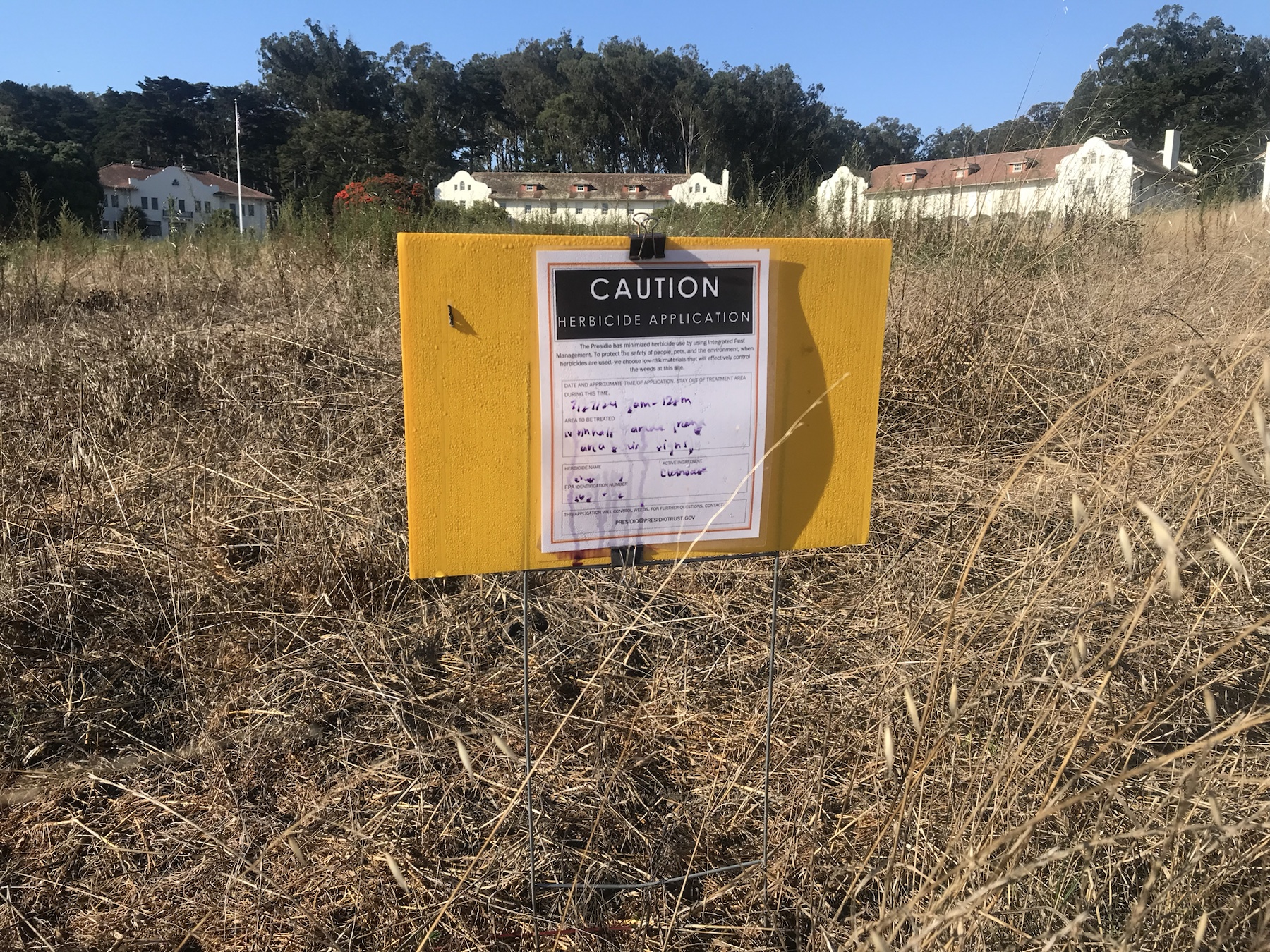 Context image of herbicide application signage in dry grass at the North Half Parade Ground