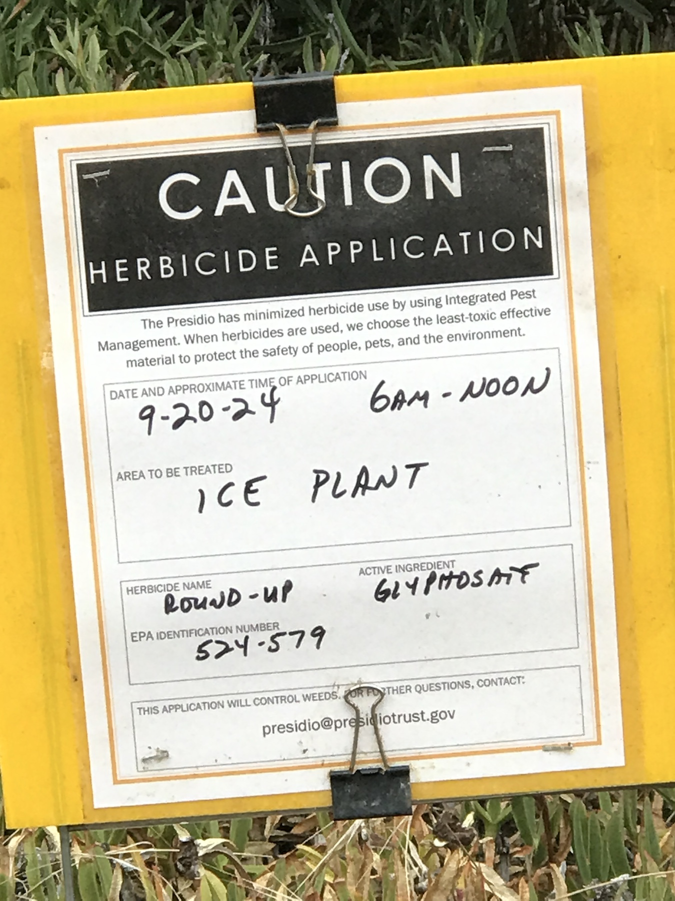Caution herbicide application sign listing Roundup and glyphosate for ice plant treatment