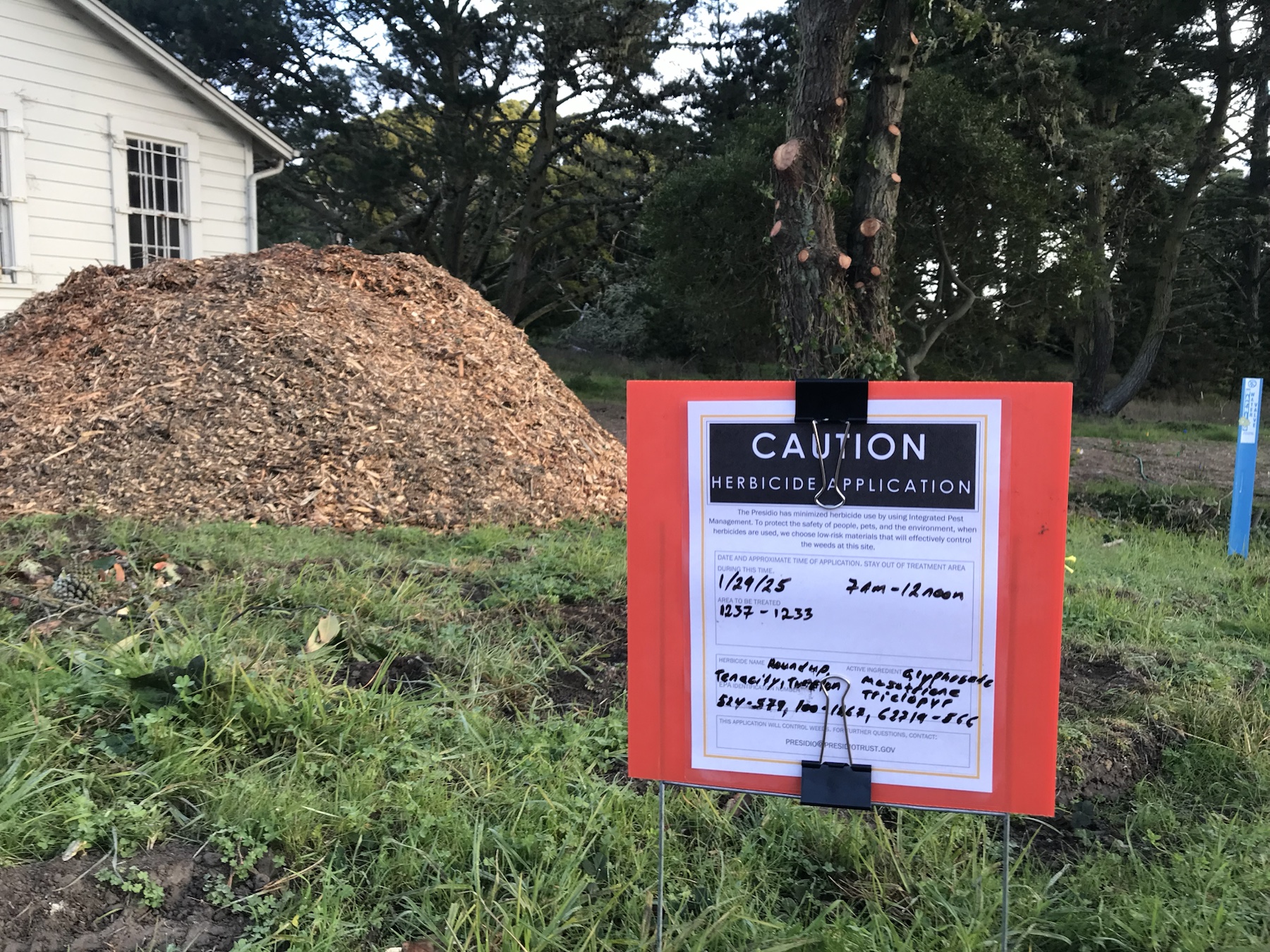 Context image of a herbicide application sign in a planted area near Presidio buildings 1233 to 1237
