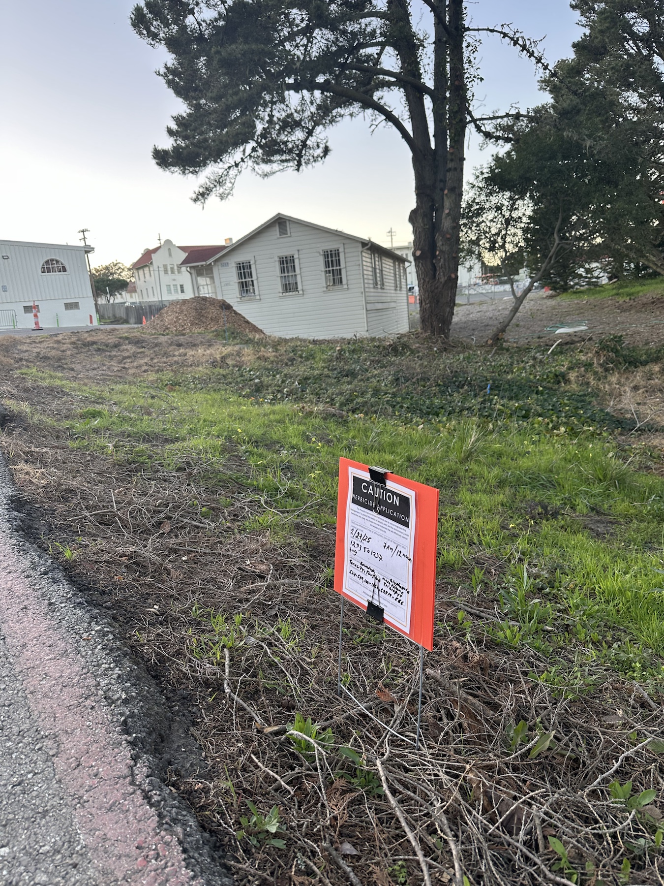 Context image of a herbicide application sign in a planted area near Presidio buildings 1233 to 1237