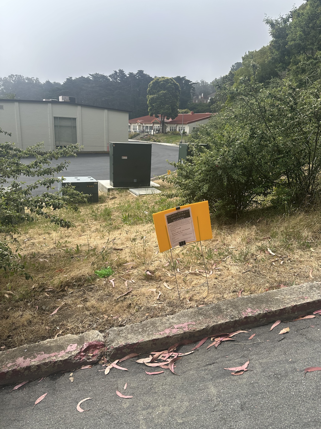 Wider context image of a Suppress herbicide sign on a slope below Infantry Terrace