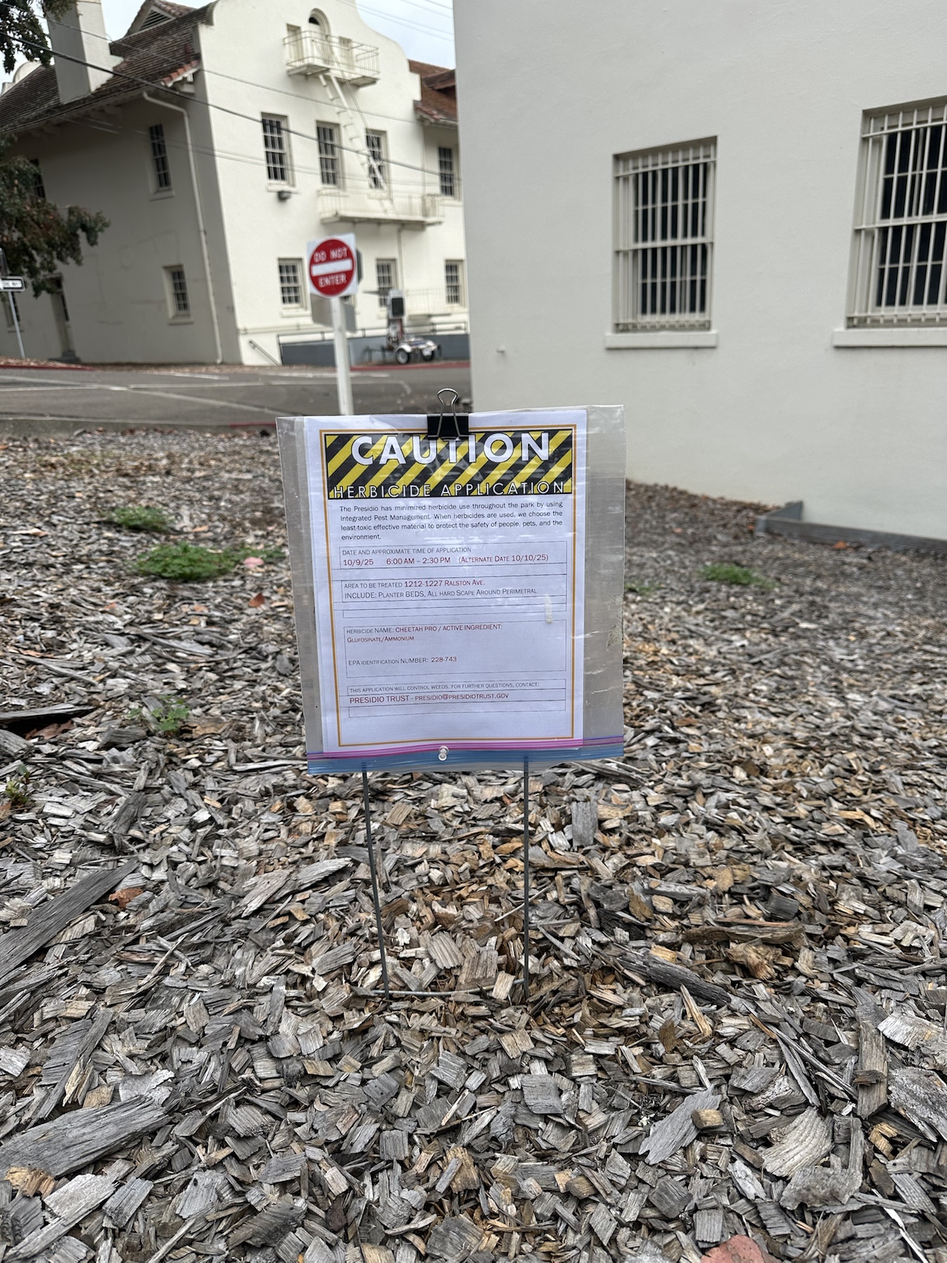 Cheetah Pro herbicide application sign posted in landscape bed near Ralston Ave building