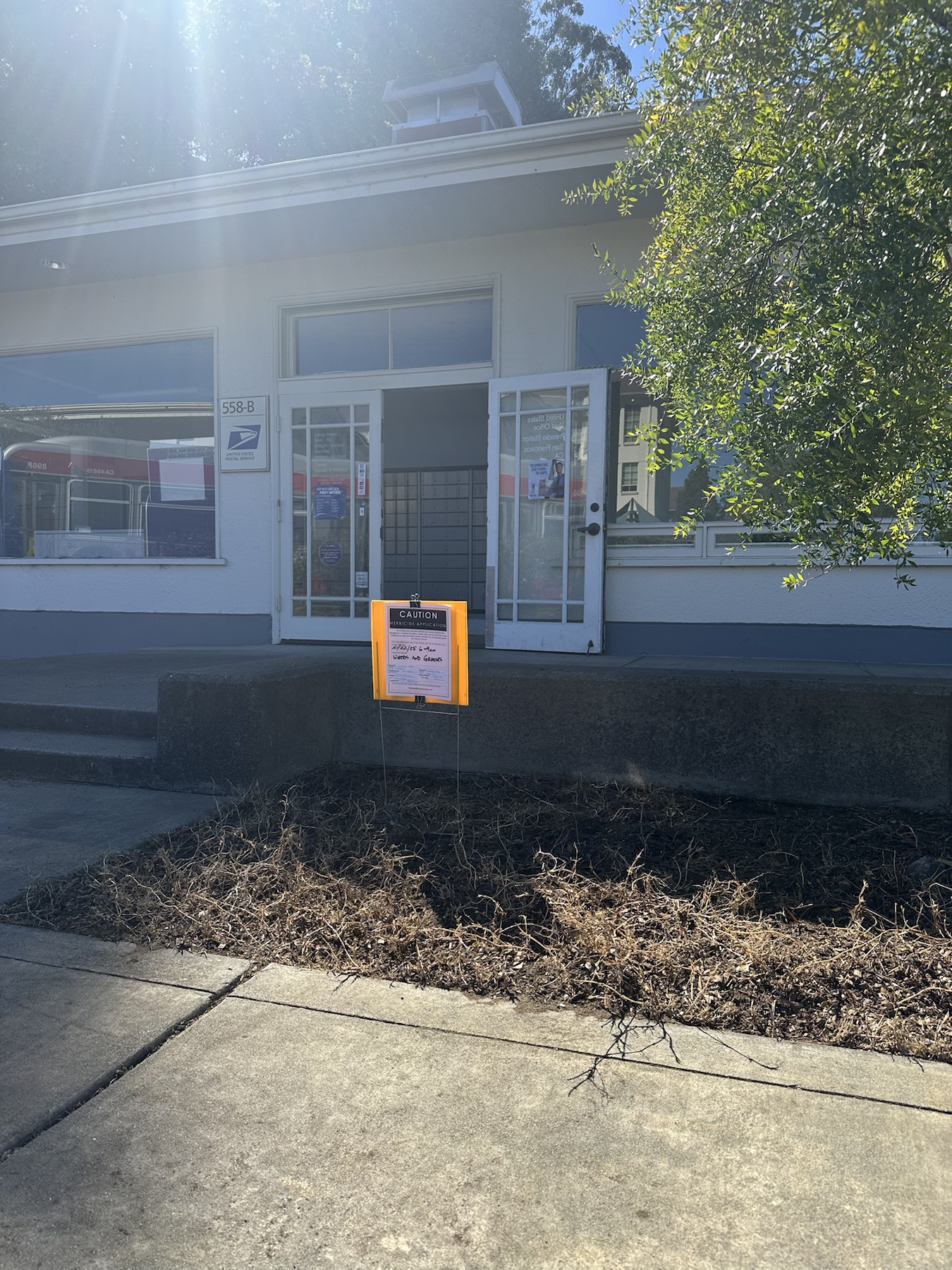 Wide context image of herbicide application sign outside USPS 558-B