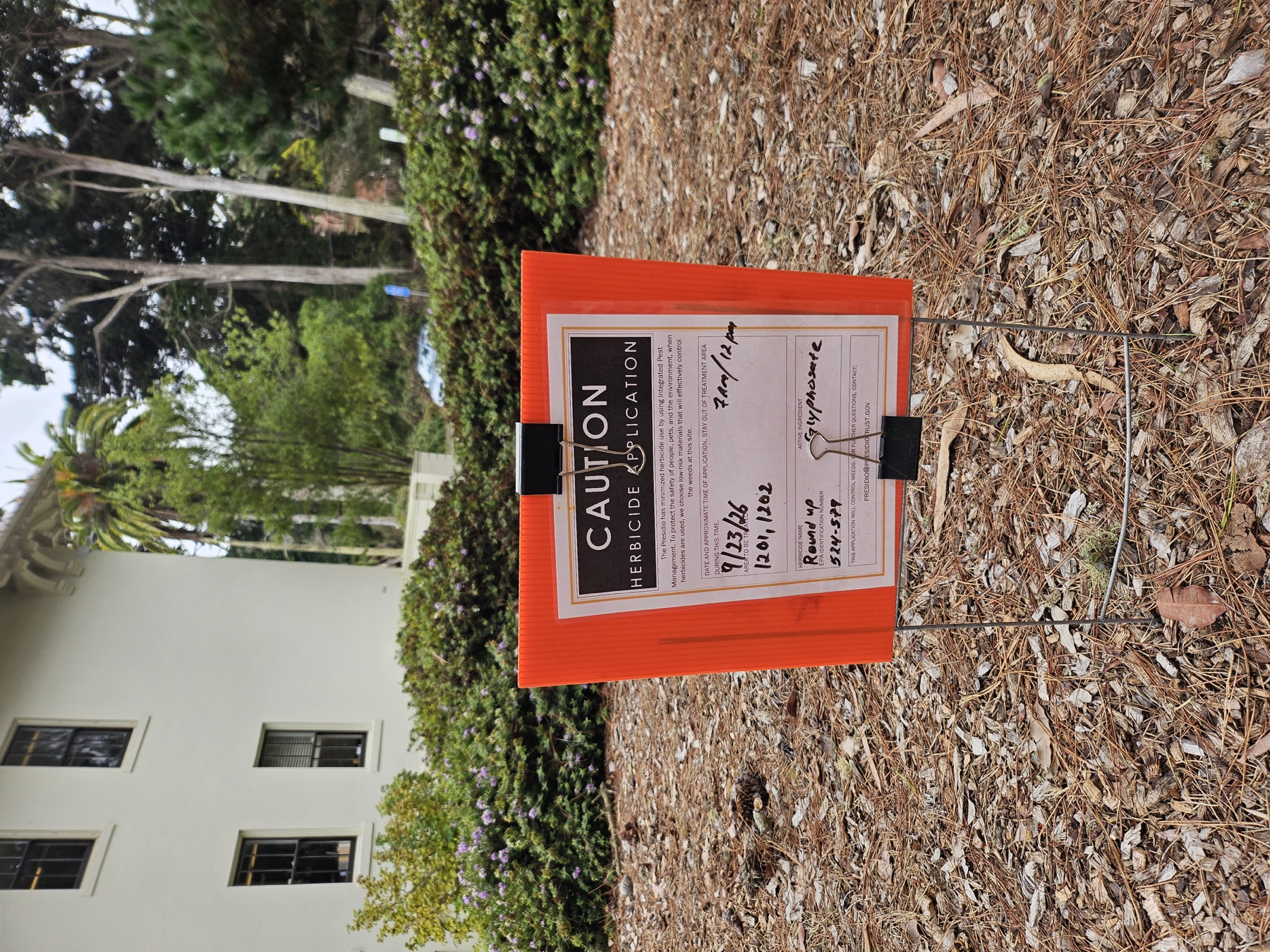 Caution herbicide application sign listing Roundup and glyphosate for Buildings 1201 and 1202